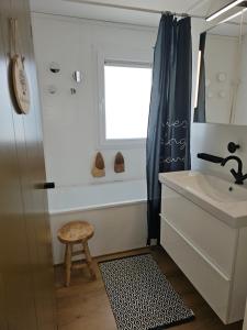 a bathroom with a sink and a window and a stool at O'Blanche, Viroinval Treignes in Treignes