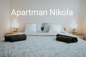 a large bed with two pillows on top of it at Apartman Nikola in Gospić