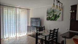 d'une salle à manger avec une table, des chaises et une fenêtre. dans l'établissement Apartment in the picturesque Oasis Resort & Spa, à Lozenets
