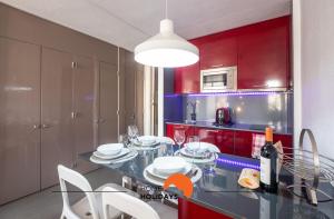 cocina con armarios rojos, mesa y sillas en #070 T0 Edifício Albufeira by Home Holidays, en Albufeira