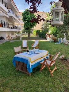 a table and chairs in the grass with a bottle of wine at Cozy apartment close to the sea in Perea