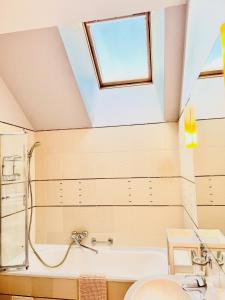a bathroom with a skylight and a tub and a sink at Super Apartment Old town in Klaipėda