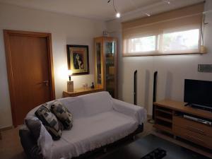 a living room with a couch and a television at Cozy apartment close to the sea in Perea