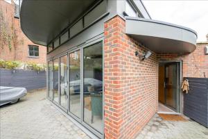 The Studio House - Crouch End في لندن: مبنى من الطوب مع نوافذ زجاجية على جانبه