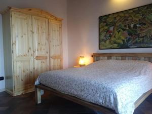 een slaapkamer met een bed en een schilderij aan de muur bij Villetta in collina Casa Calmàs in Brione