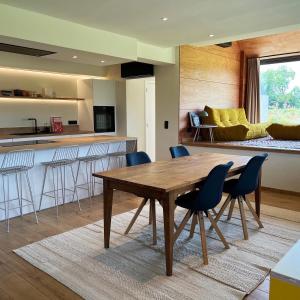 a kitchen and living room with a wooden table and chairs at Maison Coucou in Thuin