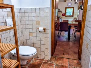 a bathroom with a toilet and a dining room at Jakob Cabin in Bovec