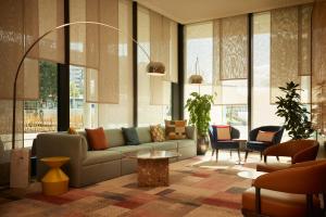 uma sala de estar com um sofá e uma mesa em Adina Apartment Hotel Geneva em Genebra