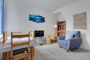 a living room with a chair and a tv at Cosy home by the sea in Cleethorpes