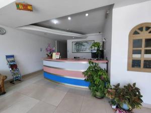 een lobby met een balie en planten in een kamer bij Century Hotel Inanam in Kota Kinabalu