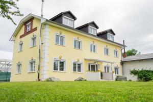 una casa amarilla con techo negro en Lions Apartments - Erholung und Vergnügen in Bad Tatzmannsdorf, en Jormannsdorf