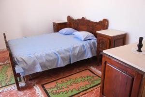 a bedroom with a bed with a wooden frame and two tables at Apartment Chez Rachida in Taguermess