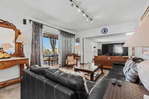 a living room with a leather couch and a television at Villa Patos in Playa Blanca