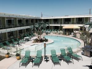 uma piscina com espreguiçadeiras em frente a um edifício em Caribbean Motel em Wildwood Crest