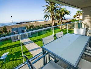 a glass balcony with a table and chairs and the beach at Las Barcas in San Agustin