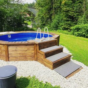 a wooden hot tub with steps next to a yard at Centrum Green Hill Business & SPA in Wisła
