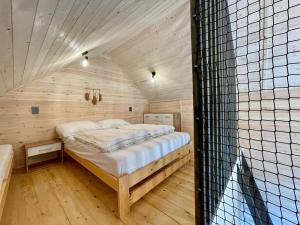 a bedroom with a bed in a wooden room at Sunmare in Sarbinowo