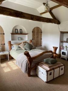 a bedroom with a large bed with a trunk in it at The Little Grebe in Swansea