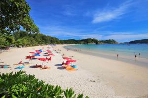 a beach with a lot of people and umbrellas at Balinese Style 3BR Villa Morning Forest, Nai Harn in Rawai Beach