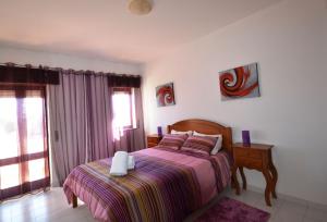 een slaapkamer met een bed, een tafel en een raam bij T3 Olhos de Água in Albufeira