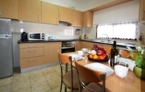 een keuken met een tafel met daarop een schaal fruit bij T3 Olhos de Água in Albufeira