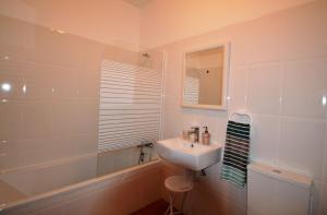 een witte badkamer met een wastafel en een bad bij T3 Olhos de Água in Albufeira +4 foto's