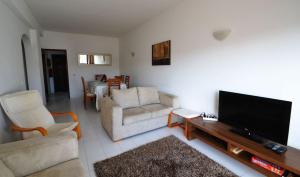een woonkamer met banken en een flatscreen-tv bij T3 Olhos de Água in Albufeira