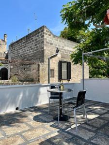 a table and a chair sitting on a patio at Housalento in Francavilla Fontana +10 photos