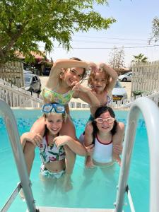 a woman and three girls in a swimming pool at Desert Sunrise Arad in Arad