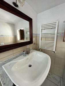 bagno con lavandino bianco e specchio di Housalento a Francavilla Fontana