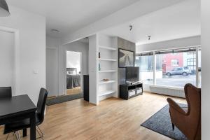 a white living room with a table and a television at Baron Downtown Apartments in Reykjavík