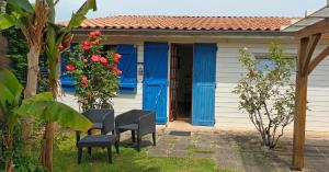 Saint-Vivien-de-MédocMaisonnette de charme entre plages et estuaire的院子里有蓝色门和椅子的房子