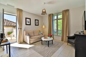 uma sala de estar com um sofá e uma mesa em Villa Meridia em Nîmes