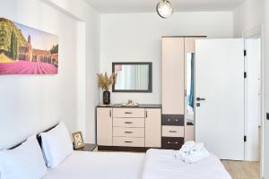 - une chambre blanche avec 2 lits et un miroir dans l'établissement Retro Apartment in Infinity Beach Resort, à Mamaia 19 autres photos