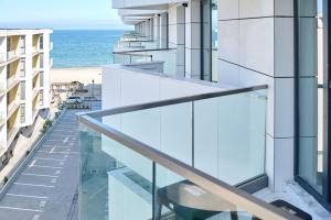 une vue sur l'océan depuis le balcon d'un immeuble dans l'établissement Retro Apartment in Infinity Beach Resort, à Mamaia