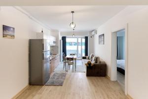 une cuisine et un salon avec un réfrigérateur et une table dans l'établissement Retro Apartment in Infinity Beach Resort, à Mamaia