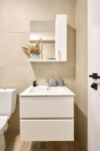 une salle de bains avec un lavabo blanc et des toilettes dans l'établissement Retro Apartment in Infinity Beach Resort, à Mamaia
