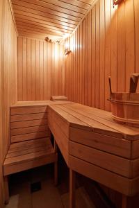 a wooden sauna with a bench and a bucket at Stabu Sēta Residence in Riga