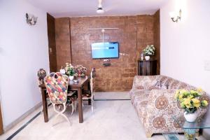 un soggiorno con divano, tavolo e TV di Divine India Service Apartment,2Bhk, D-198,SAKET a Nuova Delhi