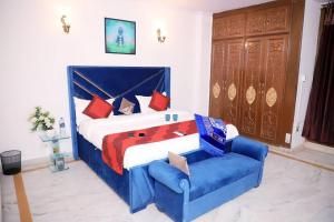 una camera con un grande letto e un divano blu di Divine India Service Apartment,2Bhk, D-198,SAKET a Nuova Delhi
