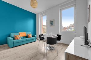 ein Wohnzimmer mit einem blauen Sofa und einem Tisch in der Unterkunft Terrasse Riquet - en plein coeur de Toulouse in Toulouse