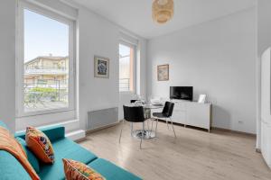 ein weißes Wohnzimmer mit einem Sofa und einem Schreibtisch in der Unterkunft Terrasse Riquet - en plein coeur de Toulouse in Toulouse