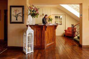 Eine Frau steht an einer Bar in einem Haus. in der Unterkunft Hylands Burren Hotel in Ballyvaughan