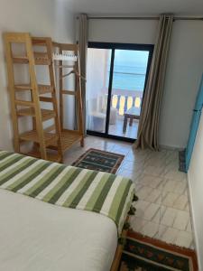 a bedroom with a bed and a view of the ocean at Single fin beach house in Taghazout