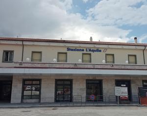 a building with a sign on the top of it at Hotel Porta Rivera Plesso Stazione in LʼAquila