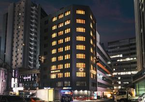 un grand bâtiment avec de nombreuses fenêtres dans une ville la nuit dans l'établissement UH Suite Central Seoul, à Séoul