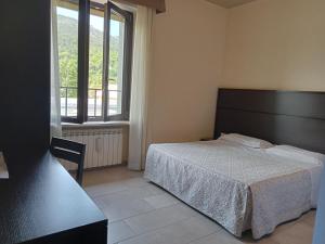 una camera con un letto e una grande finestra di Hotel Porta Rivera Plesso Stazione a L'Aquila