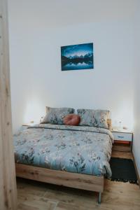 a bedroom with a bed with a blue comforter at Apartman Nikola in Gospić