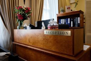 a reception desk in a hotel room with flowers at Stabu Sēta Residence in Riga