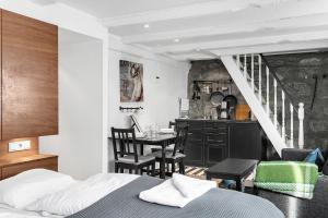 a bedroom with a bed and a table and a kitchen at Baron Downtown Apartments in Reykjavík